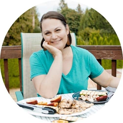 短棕色头发妇女身穿Tealt衬衣坐在一张表板上盘加烤食品